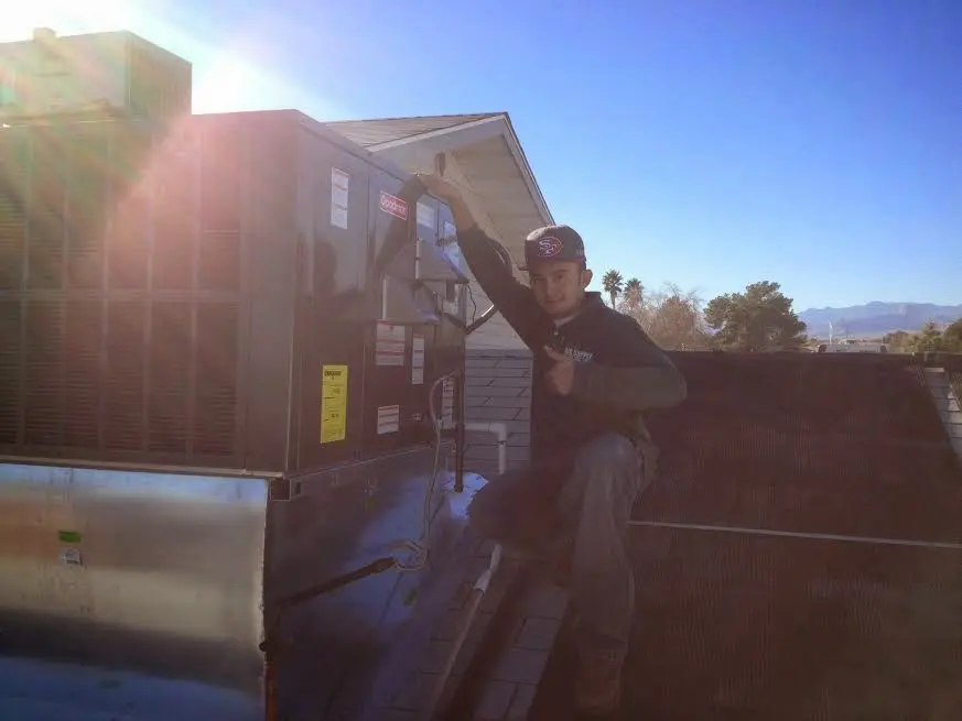 HVAC technician performing HVAC Inspection on a rooftop unit in Morristown