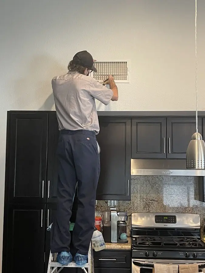 Technician inspecting an air vent during HVAC service in Morristown